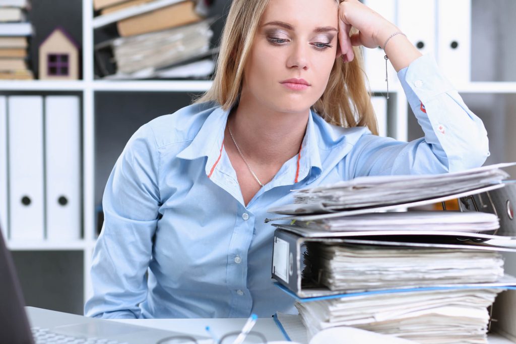 tired female employee facing files for independent contractor management
